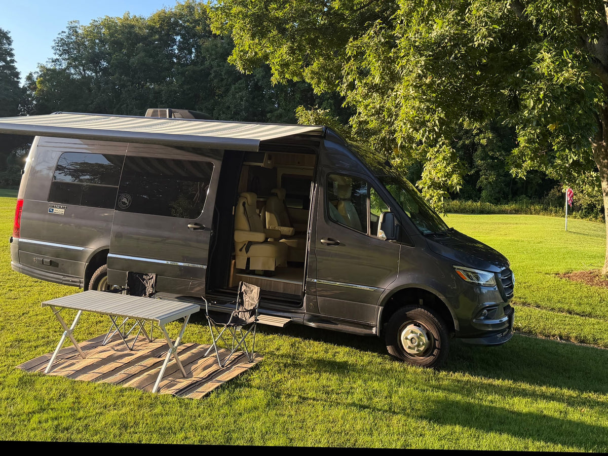  and TV in this compact camper.|RV rental: Dark camper van with awning & table by a tranquil lake — photo 14