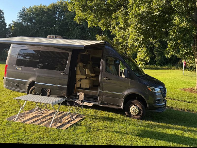  and TV in this compact camper.|RV rental: Dark camper van with awning & table by a tranquil lake — photo 14