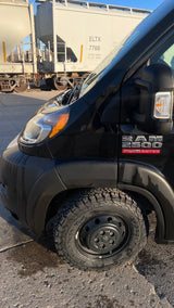 Black Ram ProMaster 2500 van with rugged tires, ideal for an rv rental adventure, parked by train cars.