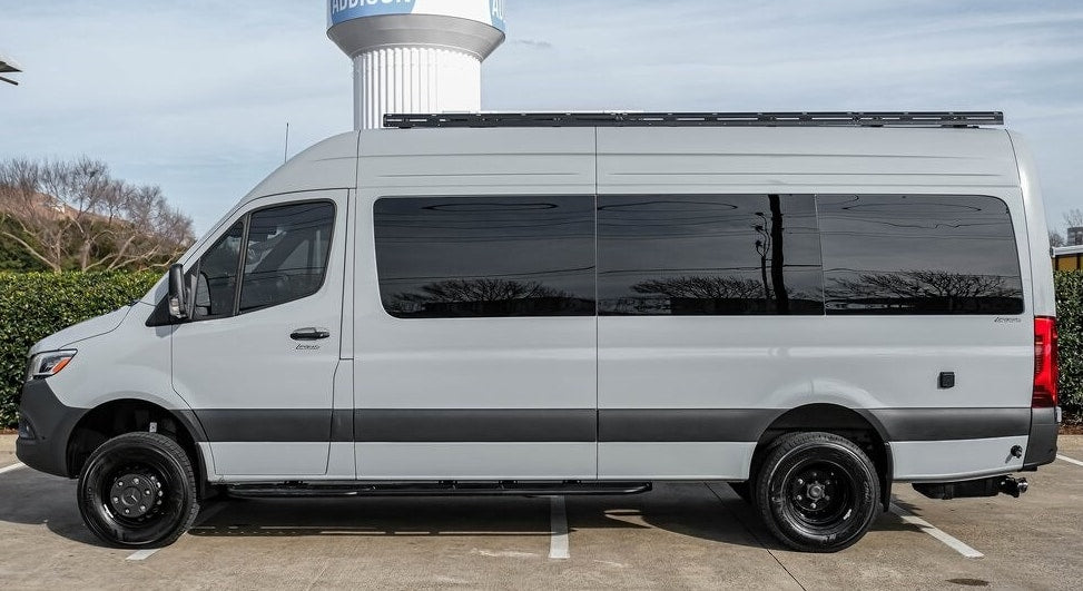 Light grey adventure camper van for rv rental, featuring dark tinted windows and a roof rack. Perfect for your next journey. — photo 4
