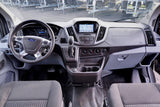 Ford Transit van interior for RV rental: spacious dashboard, steering wheel, and navigation screen for easy travel.