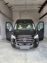 Discover this new black Mercedes-Benz Sprinter van, perfect for rv rental. Front doors open, showcasing a luxurious interior.