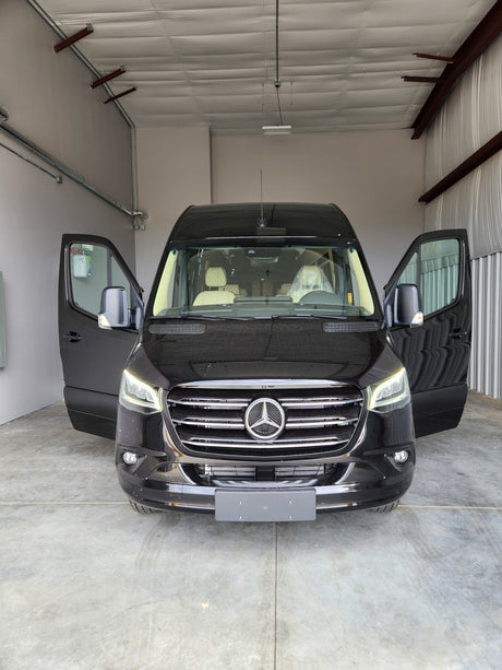 Discover this new black Mercedes-Benz Sprinter van, perfect for rv rental. Front doors open, showcasing a luxurious interior.