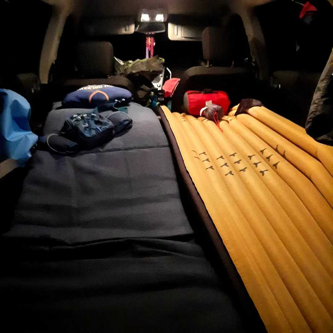 Comfy SUV car camping bed with sleeping mats & gear. A great alternative to an RV rental for your adventure trip.
