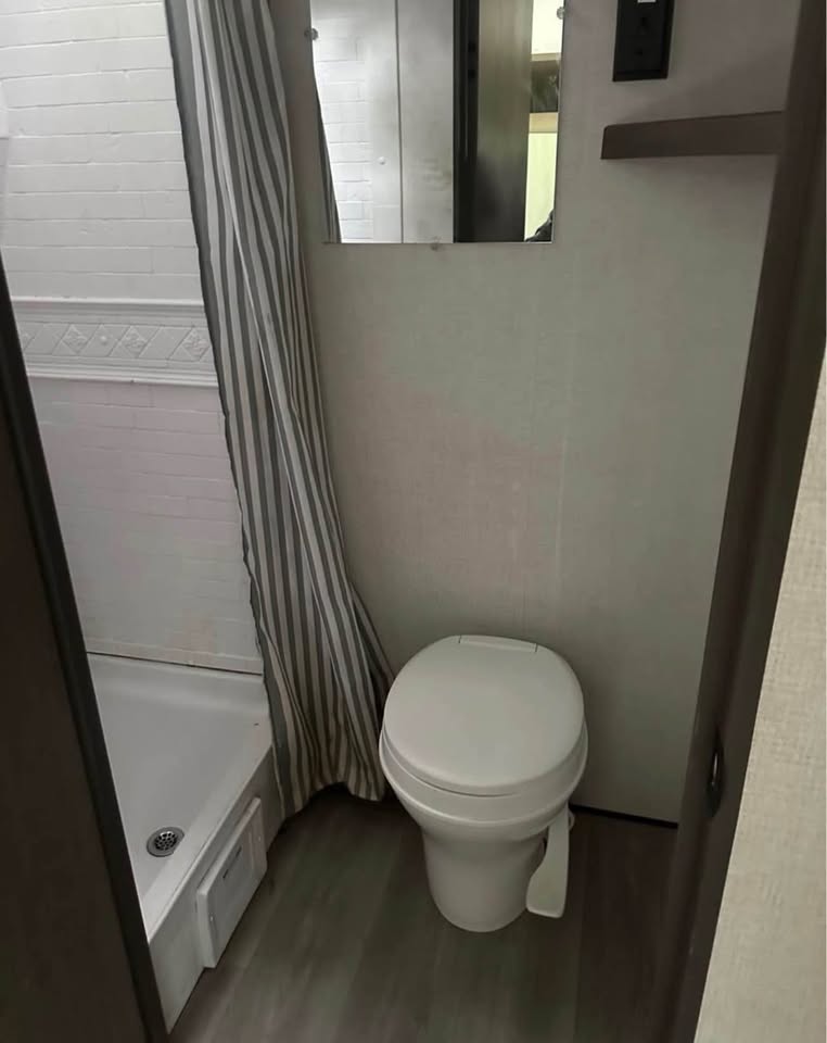  and under-seat storage for your next adventure.|Cozy bed with a portable solar charger kit inside an RV rental. Features overhead storage — photo 6