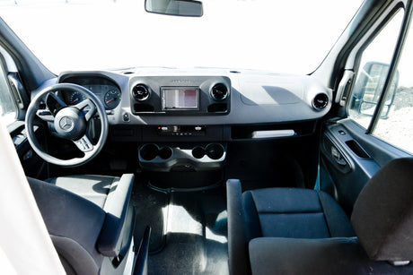 rv rental Mercedes-Benz Sprinter van interior: dashboard, steering wheel, infotainment system, and front seats are clearly visible.