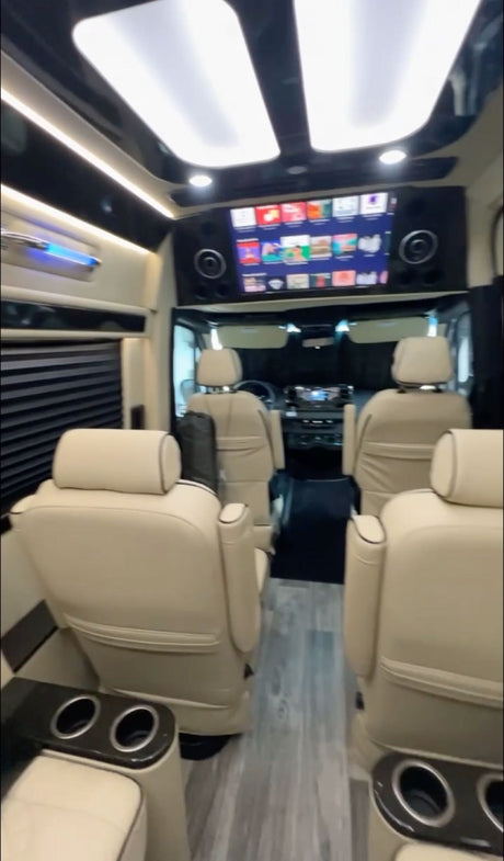 Luxury RV rental interior with plush seating, entertainment screen, and ambient lighting. Ideal for travel comfort!