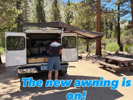 RV rental truck camper with new awning up! A person preps inside at a scenic camping spot. Great for outdoor travel.|Relaxing inside an RV rental with a dog