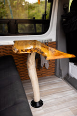 Inside our RV rental: a beautiful custom live-edge wood table with a natural log base and comfortable seating.