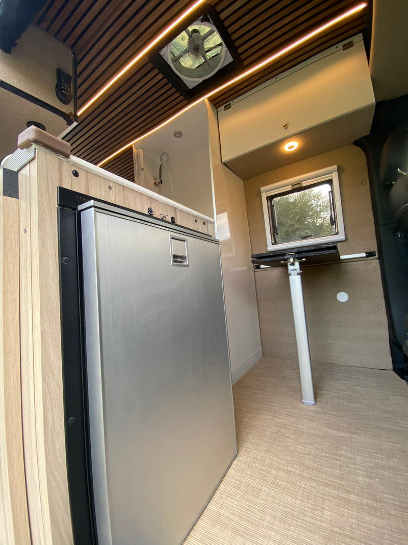  and wood-slatted ceiling.|Well-appointed RV rental camper van interior shows a bed — photo 16