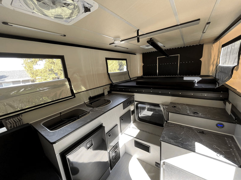  and large windows.|Explore this pop-up RV rental interior. It features a cozy dinette — photo 7