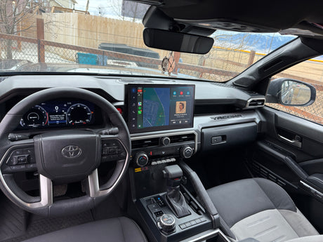 Modern Toyota Tacoma interior: digital dash, large infotainment screen with map & music. Ready for adventures, or an rv rental journey.