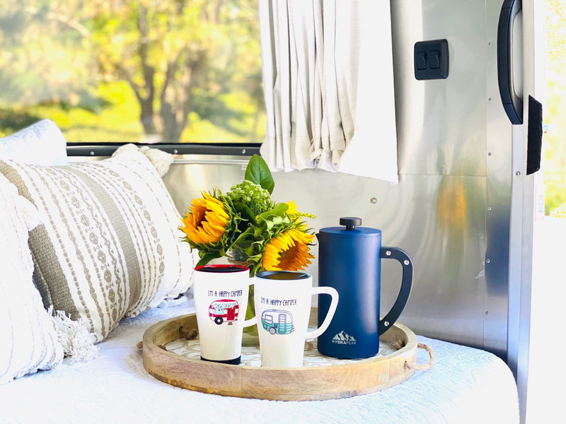  blue knife on a nature-themed placemat. Enjoy glamping!|Four "Happy Camper" mugs featuring various RVs — photo 18