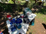 Perfect RV rental setup: Coleman stove, lantern, enamelware, and ENO hammocks for comfortable camping.