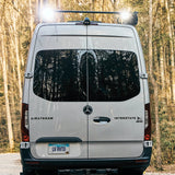 Rear view of a silver Airstream Interstate X 4WD Mercedes RV in the woods. Perfect for an rv rental adventure!