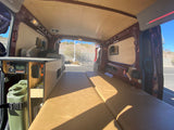 Inside this **rv rental**, find a custom camper van interior with a cozy bed, power system, and built-in storage.