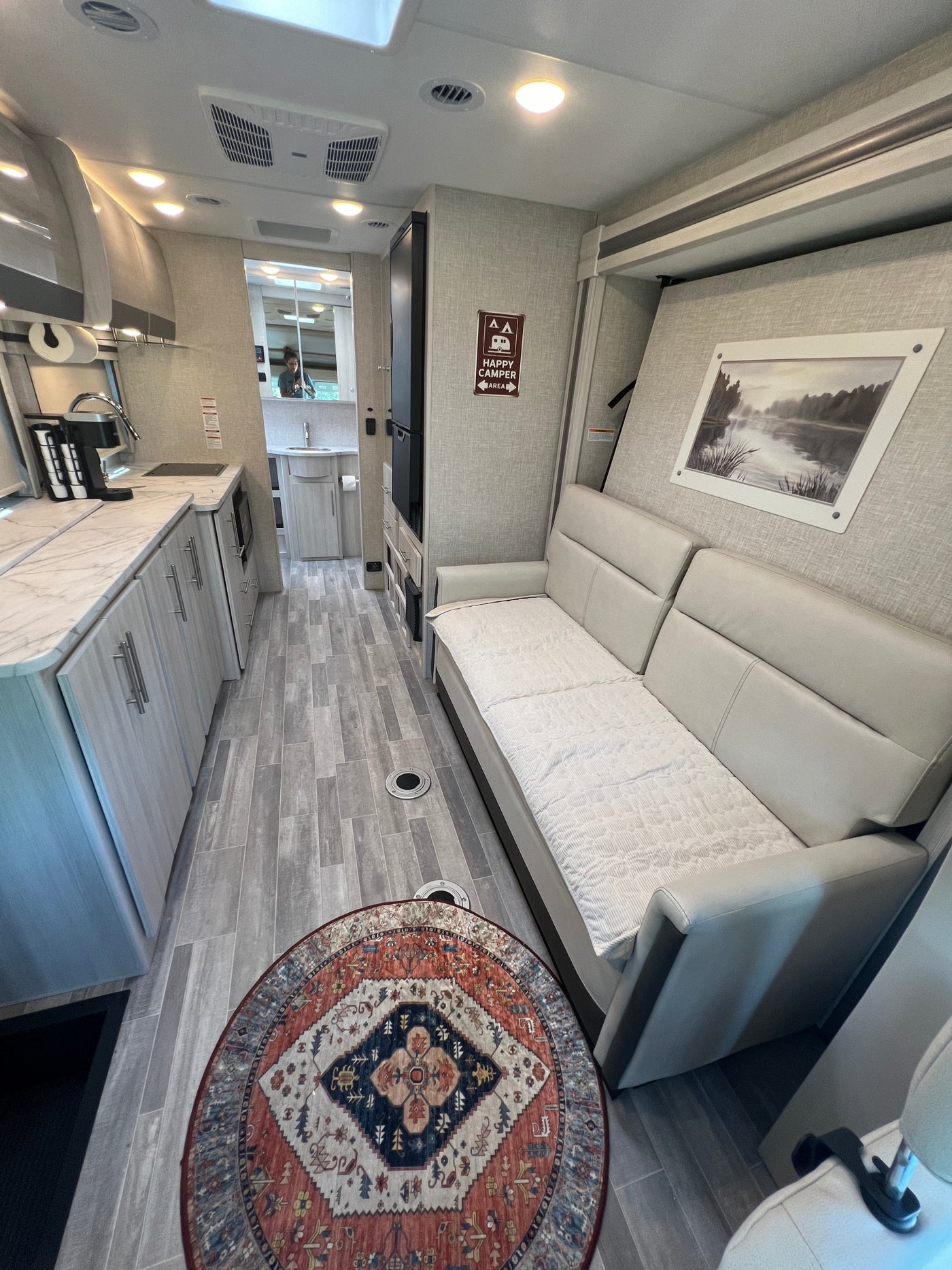 Explore this clean rv rental interior featuring a modern kitchen, comfortable sofa, and compact bathroom. — photo 17