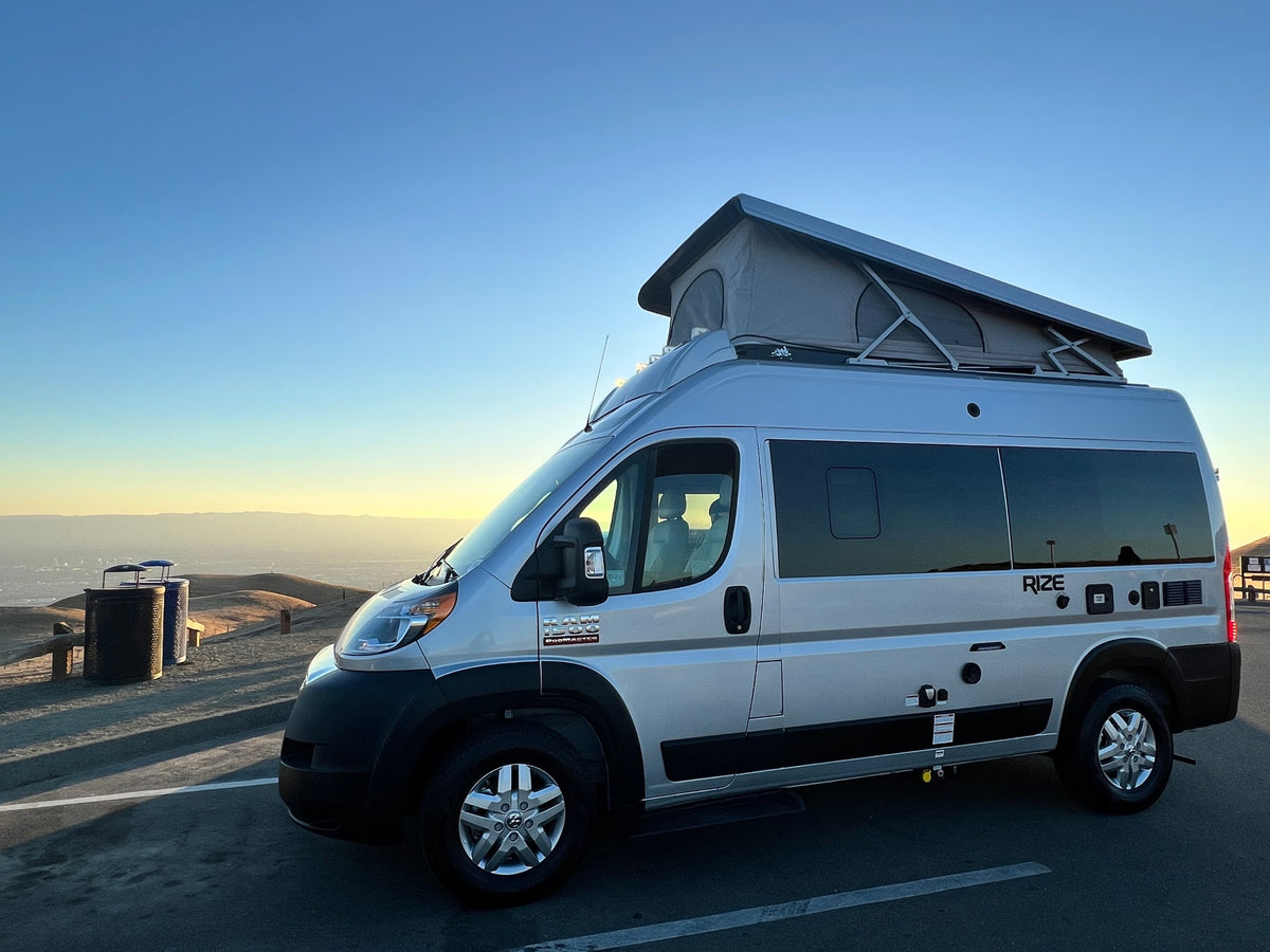 This silver pop-top Ram ProMaster camper van