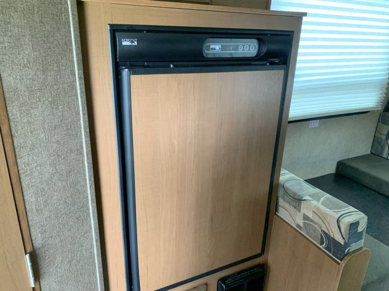  and wooden cabinets.|RV rental interior: overhead cabinet with built-in stereo and storage cubby for entertainment & convenience.|RV rental: See the compact bathroom with a vanity — photo 17