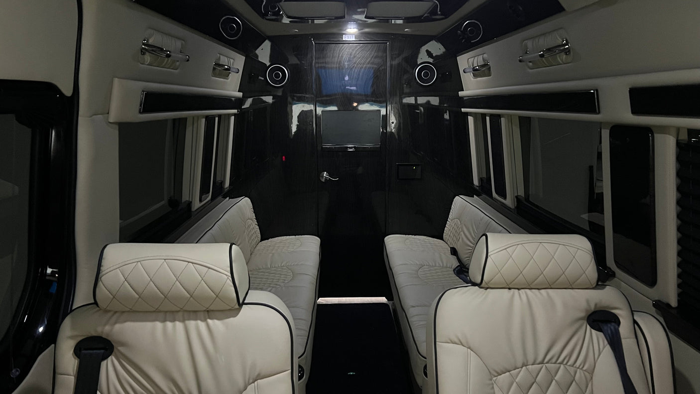 Premium rv rental interior with facing quilted seats, ceiling speakers, and entertainment screen for comfort.