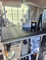 Compact RV rental kitchen setup with sink, storage, and cozy decor, perfect for mobile living.