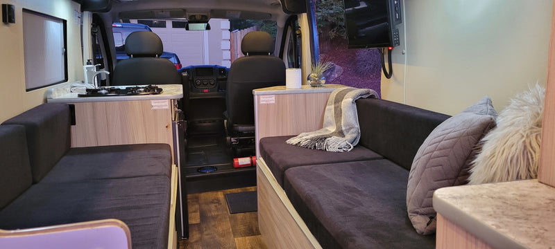 Spacious, modern RV rental interior with convertible seating, kitchen, entertainment, and front cabin view. Ready for adventure! — photo 1