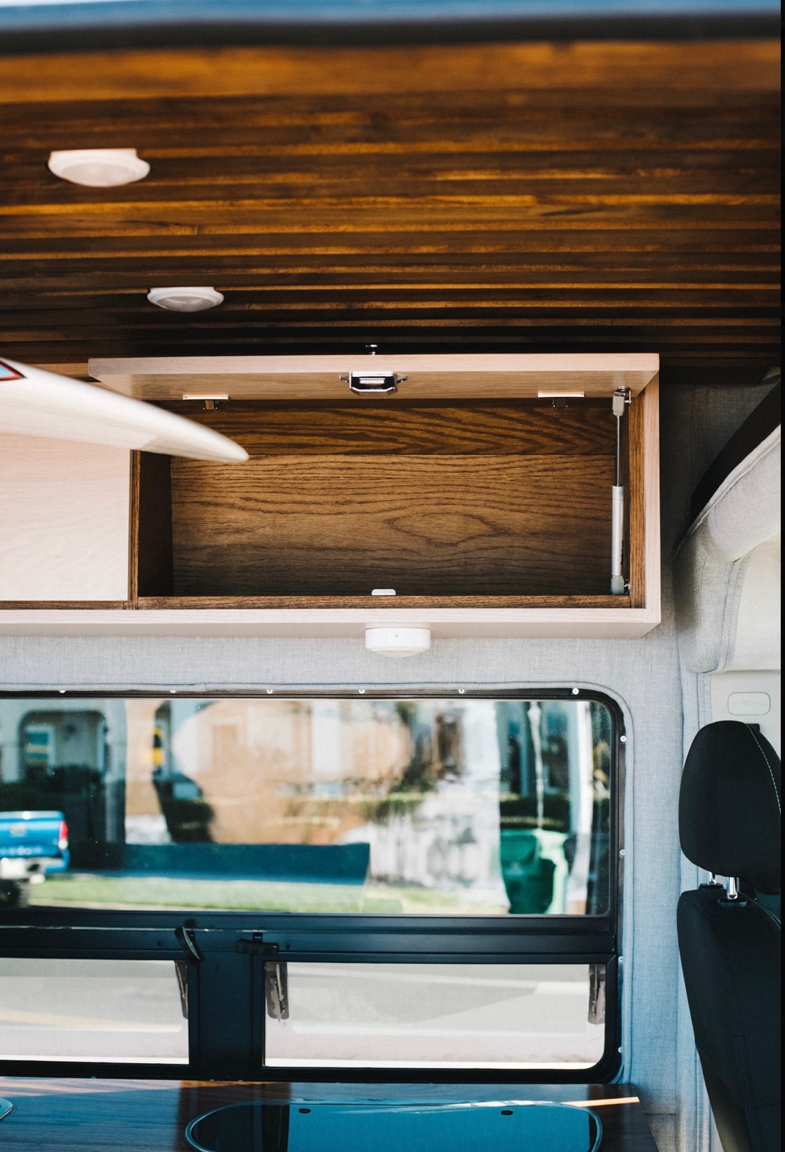  and under-bed storage with a red kayak.|A red surfboard is cleverly stored on a pull-out tray in this RV rental — photo 6