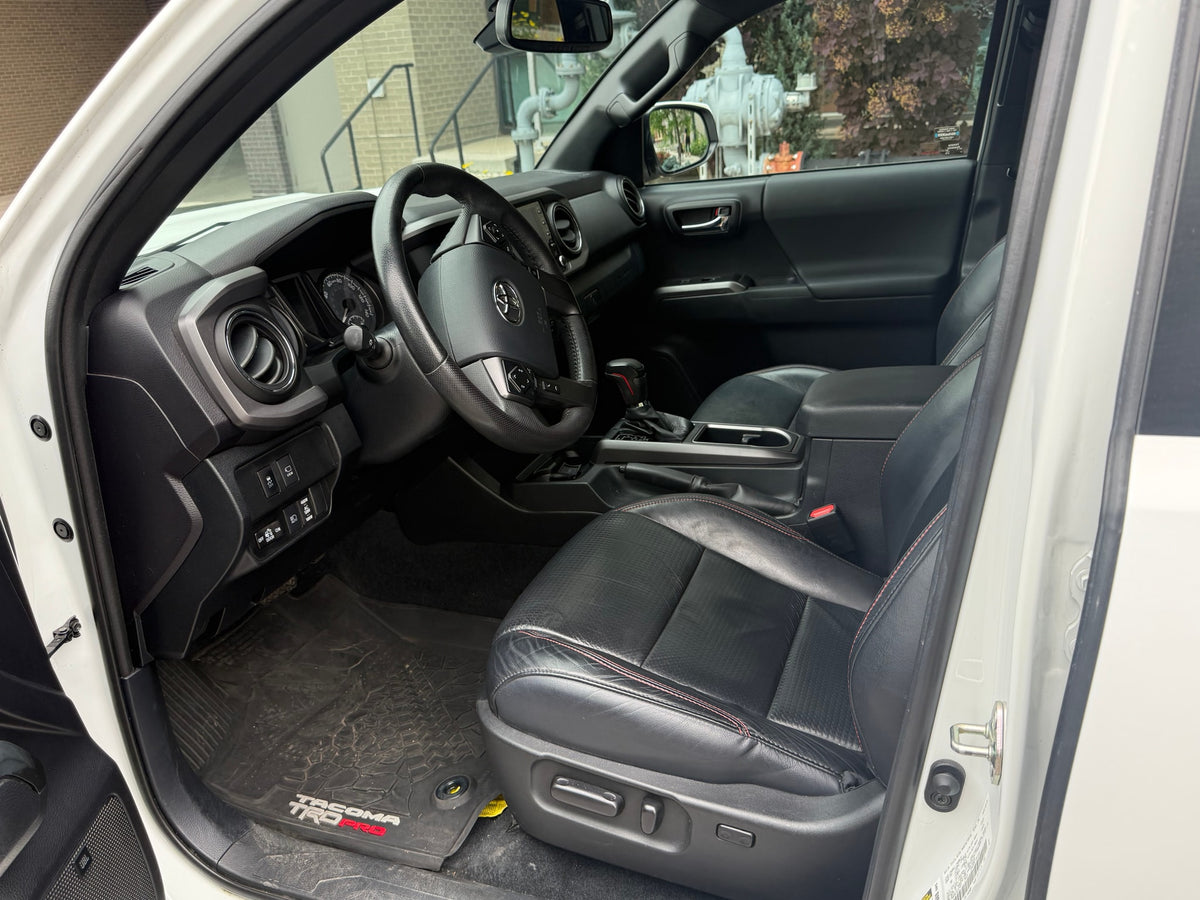 Driver's view of a clean, modern truck's black interior with leather seats, dashboard, and steering wheel. A comfortable alternative to an rv rental. — photo 9