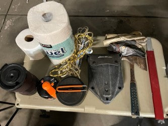 Get ready for your RV rental adventure! Paper towels, hatchet, rope, cookware, & travel essentials on a table. — photo 18