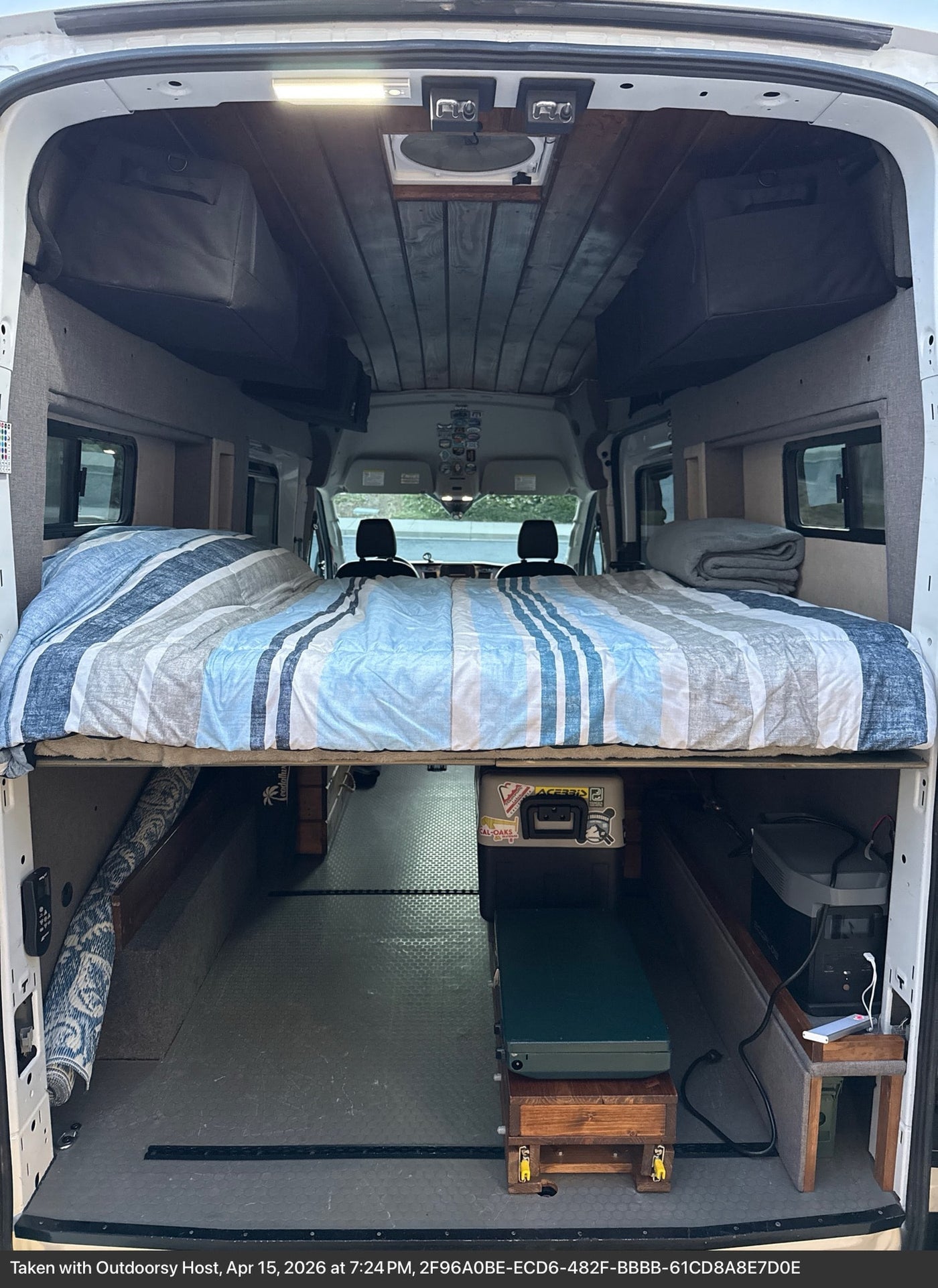  and adjacent bed. Perfect for van life adventures.|Custom RV rental interior: herringbone countertop & rustic wooden drawers with rope handles. Cozy van storage.|A portable power station — photo 11