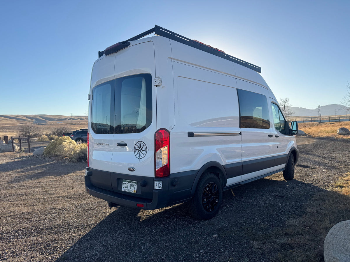  parked on gravel under a clear blue sky. Ready for adventure!|White Ford Transit camper van — photo 3