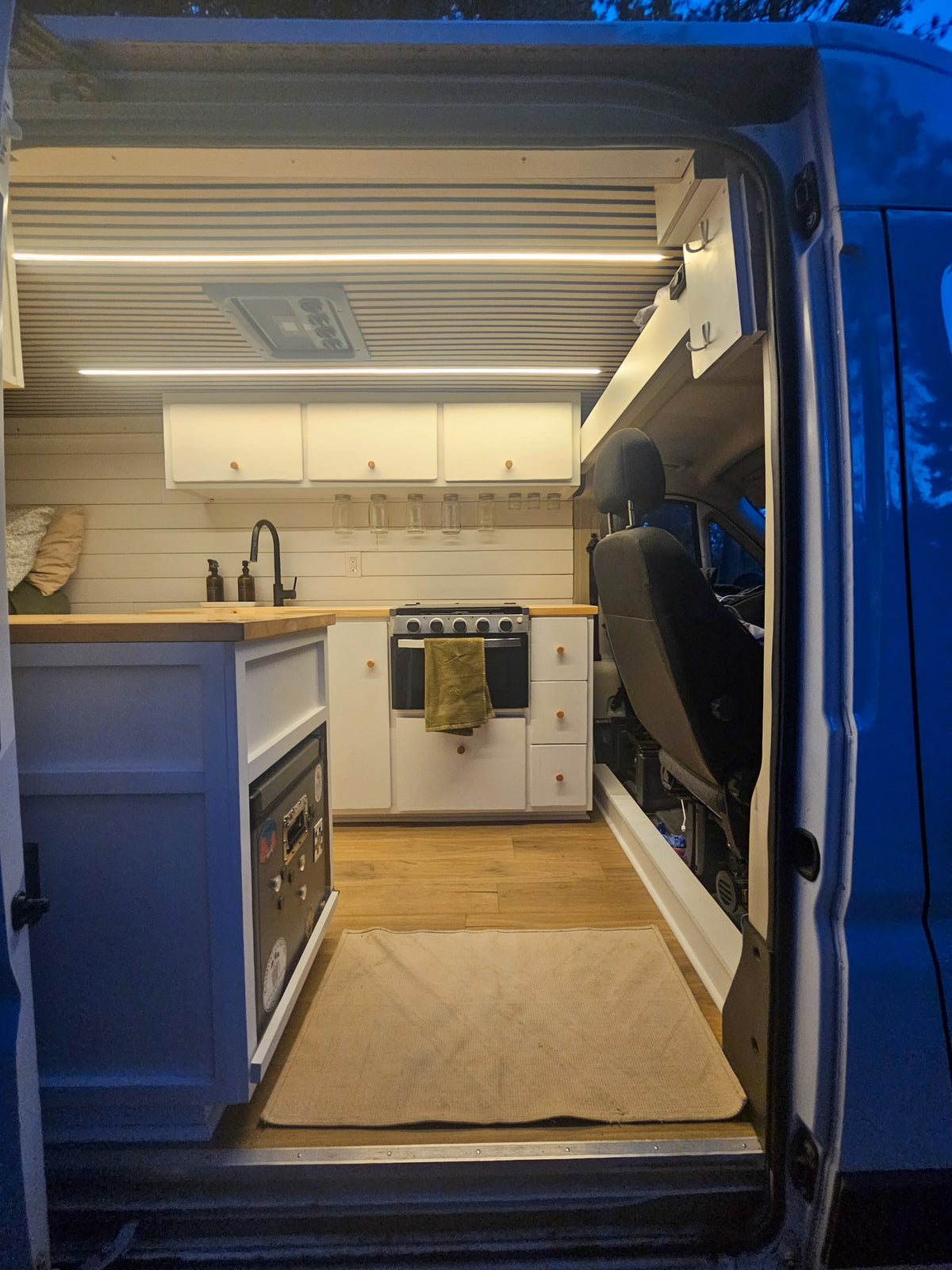  and scenic outdoor view from a camper van's front window.|Two women enjoy cards inside a stylish RV rental camper van — photo 9