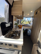 This rv rental offers a fully equipped kitchen, a comfortable bed, and expansive screened views for a great trip.