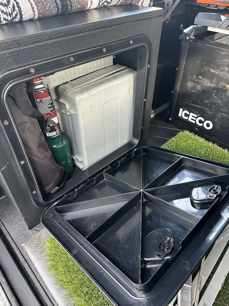 RV rental gear: ICECO portable fridge, gas stove, and propane tank organized in rear vehicle storage compartments. — photo 18