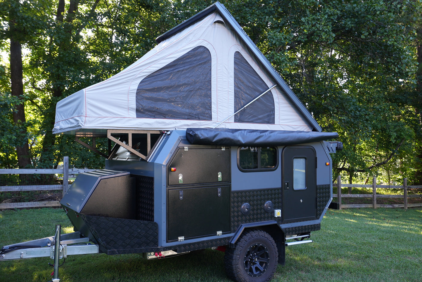Rugged dark grey off-road camper trailer with pop-top tent, ready for your next RV rental adventure.