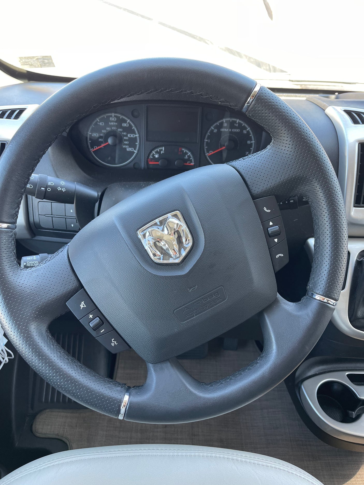 Interior of an RV rental showing the steering wheel with Ram logo, dashboard, and controls.