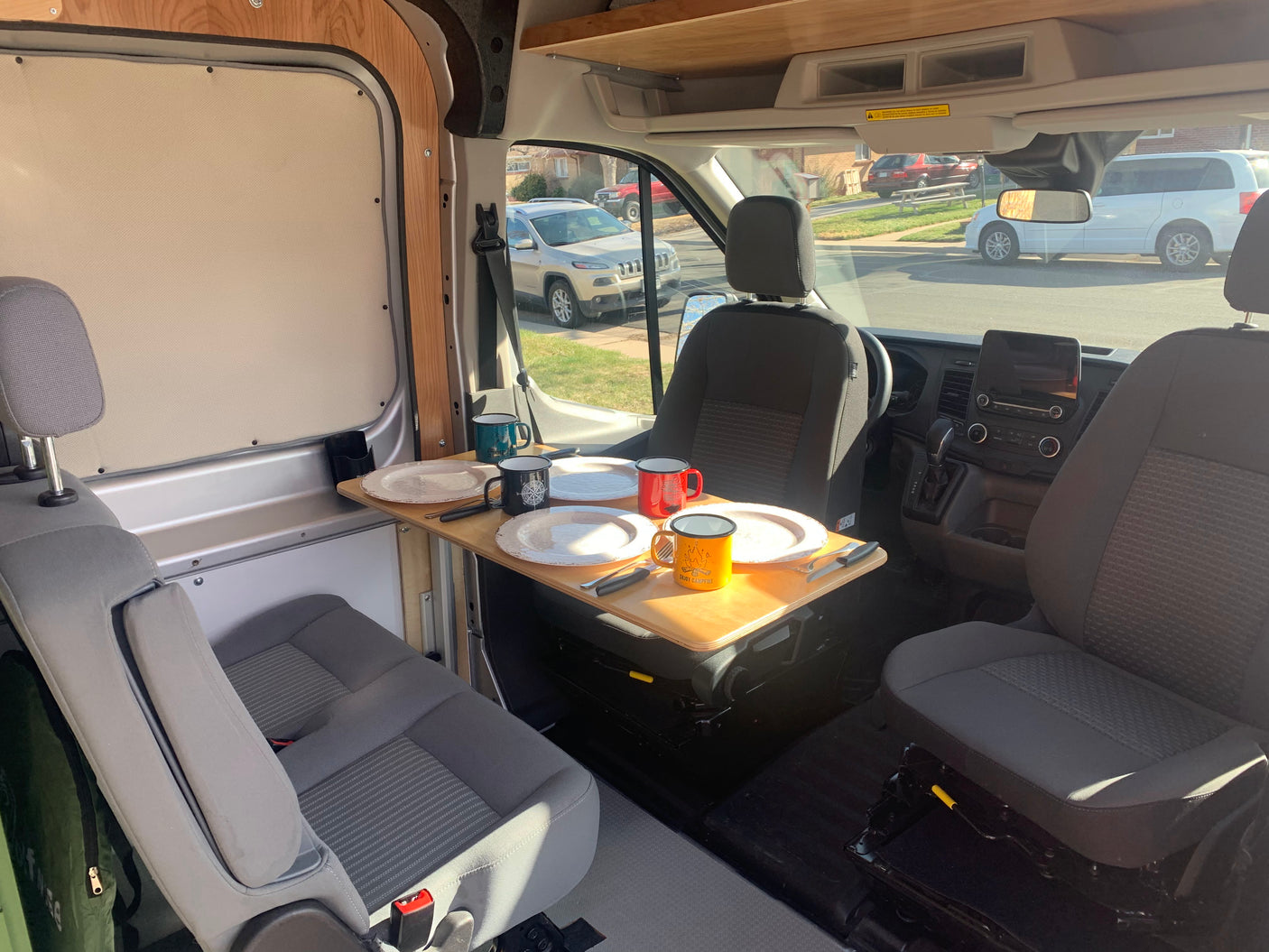 Inside this rv rental, a camper van's dining area is set with a table for four. Swivel seats create a functional space.