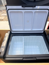 Open portable dual-zone fridge/freezer for rv rental. Shows two compartments, wire baskets, and control panel on the side.