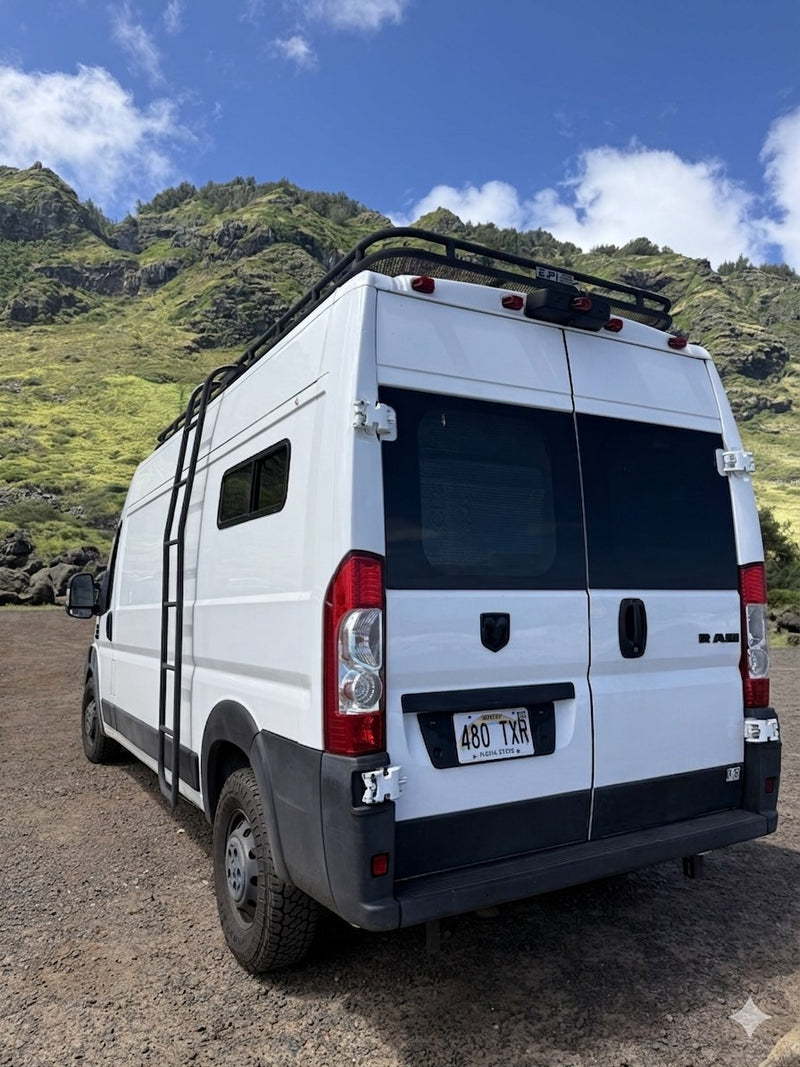  parked oceanfront under a bright blue sky for van life adventures.|Coastal RV rental: A white Ram camper van with a roof rack — photo 2