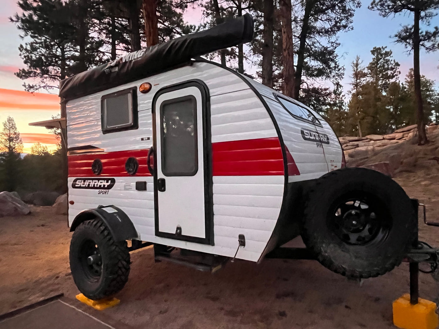 RV rental: a Sunray Sport travel trailer sits among trees at sunset, perfect for outdoor camping adventures. — photo 1