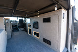 Spacious camper van interior, perfect for an RV rental adventure. Features custom storage, bed platform, and control panel.