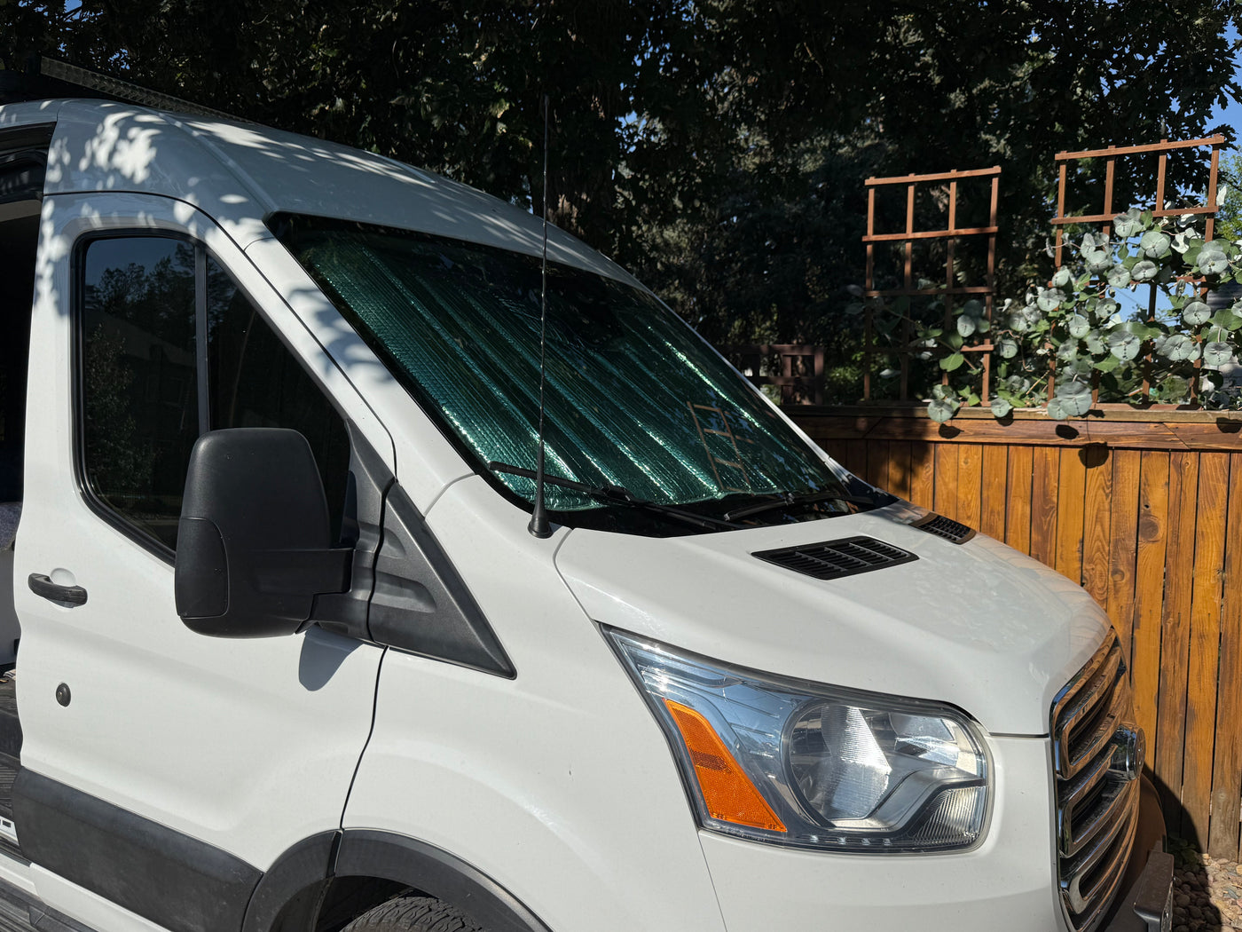 White Ford Transit camper van with sunshade, parked outdoors on a sunny day. Ideal RV rental for travel adventures. — photo 20