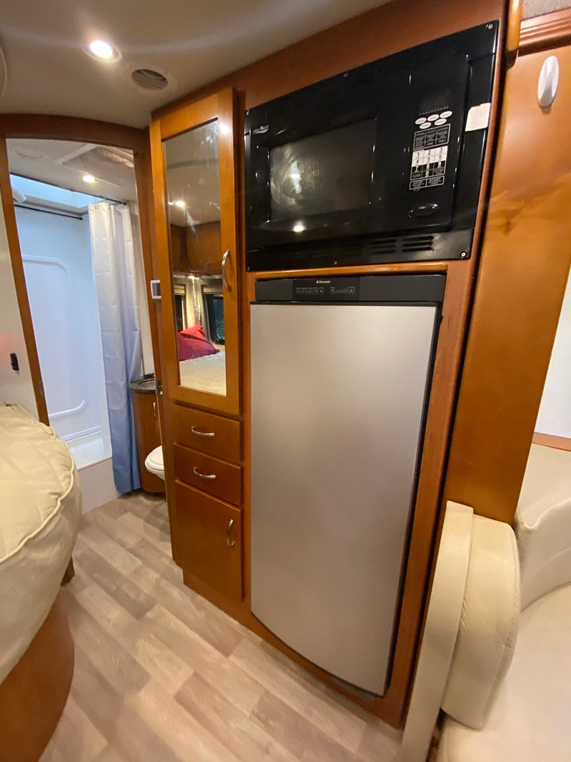  and overhead cabinets.|Cozy RV rental bedroom features a comfortable bed — photo 5