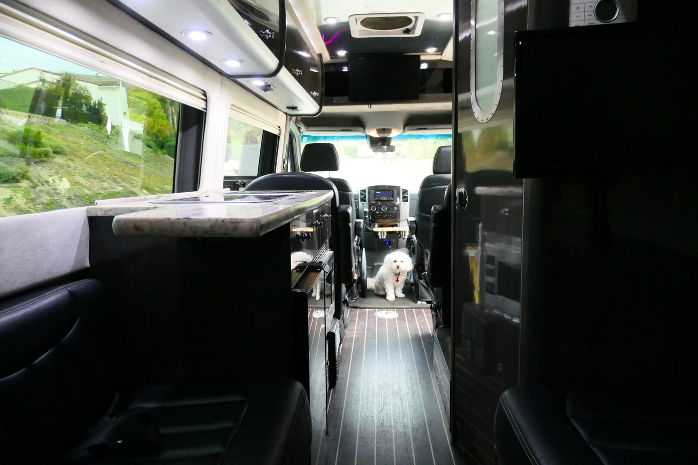  as a couple relaxes in chairs by a roadside.|Experience freedom with an RV rental! A woman on a rock admires majestic mountains beside a black Airstream.|Two young boys relax in custom bunk beds inside an RV rental — photo 11