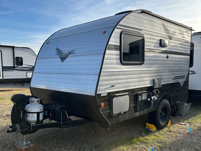 This silver and black Retro Riverside travel trailer with off-road tires is perfect for your next RV rental adventure.|Get ready for adventure! This silver and black Retro Riverside travel trailer RV rental features an open door with steps.|Compact RV rental interior showing a kitchen with stove
