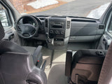 RV rental van interior: Driver's view with dashboard, steering wheel, and seating area. Ready for adventure.