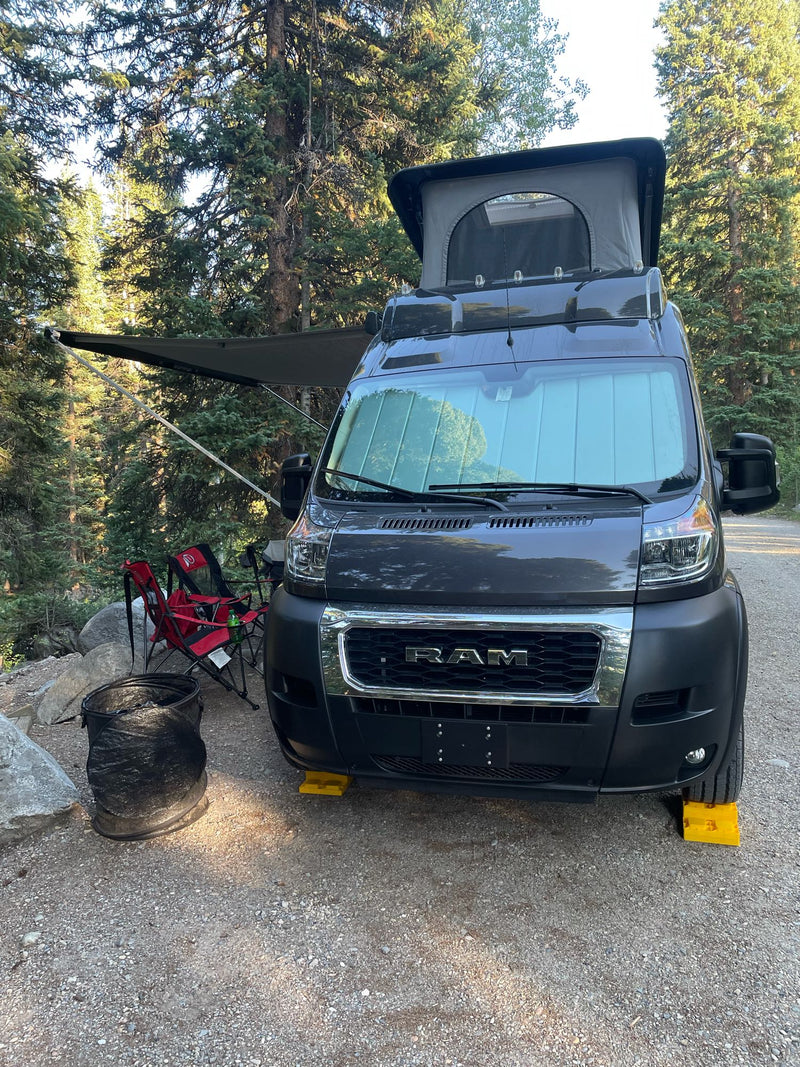 Ram ProMaster rv rental camper van with pop-top and awning, leveled at a serene forest campsite. Outdoor comfort! — photo 3