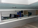 This RV rental's overhead cabinet is stocked with travel essentials like a LifeStraw, Gorilla tape, and resistance band.