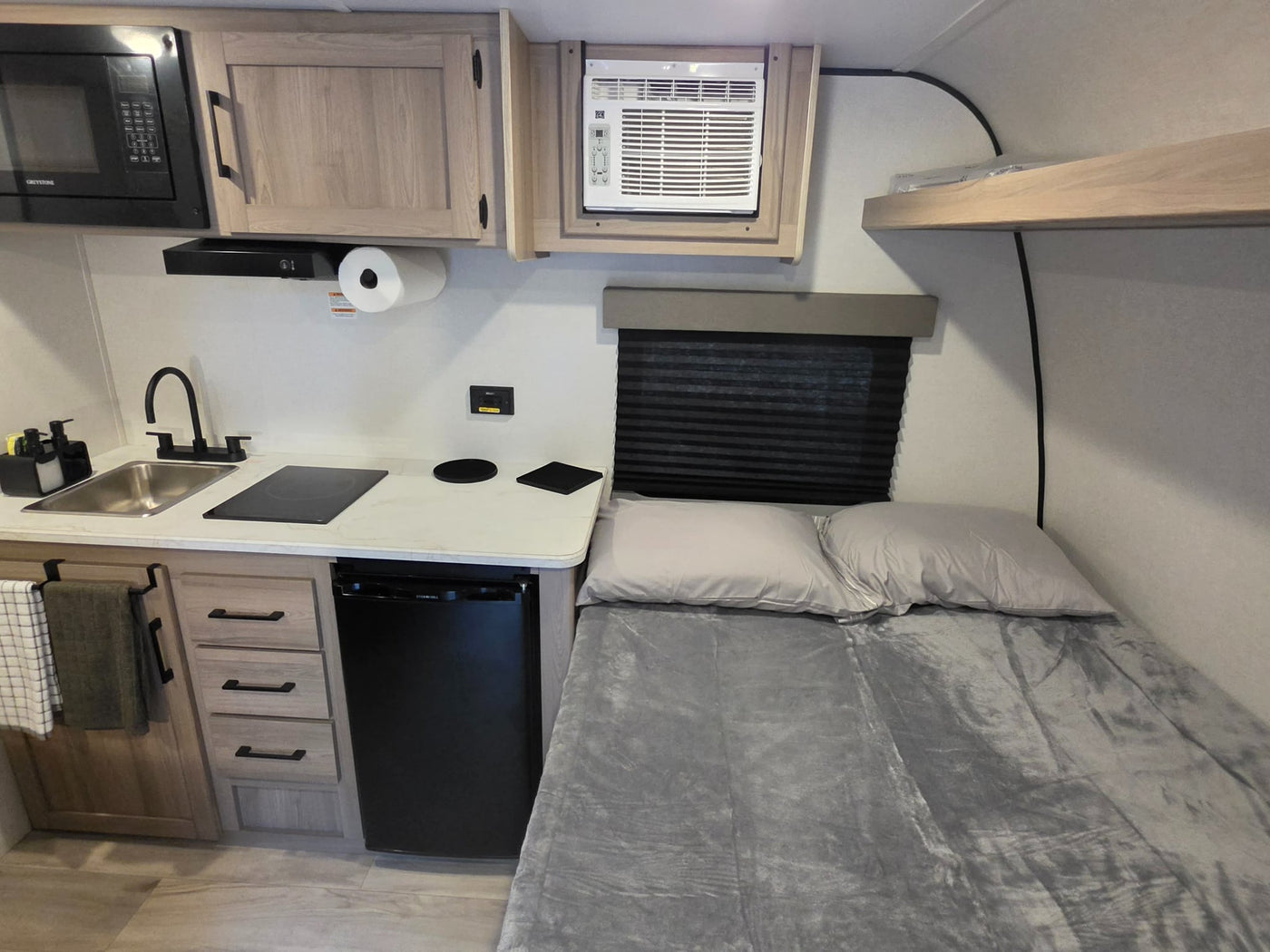  next to a shower curtain.|Compact shower interior in an RV rental — photo 5