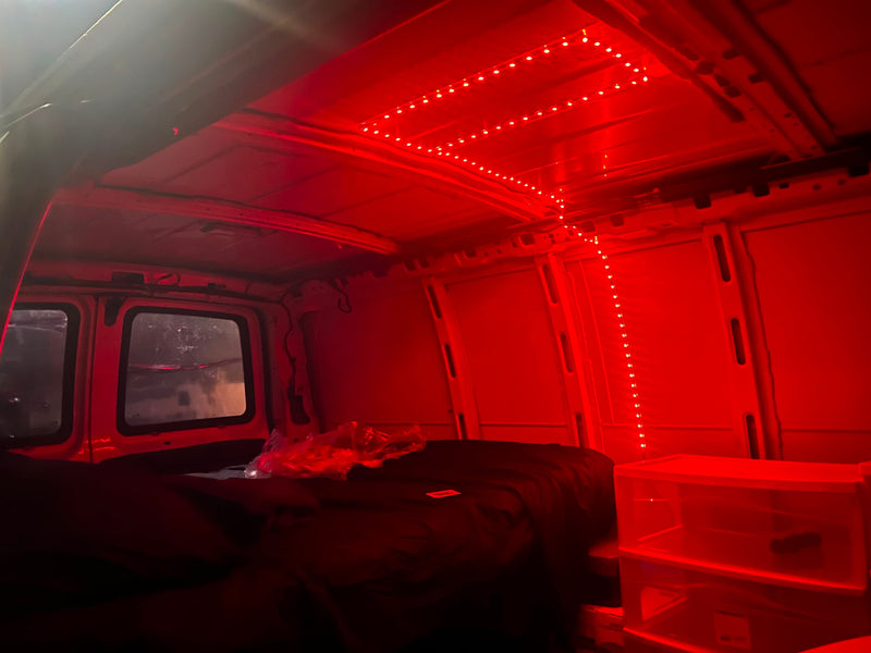  illuminating a dark bed and white plastic drawers.|Rear/side view of a white cargo van — photo 2